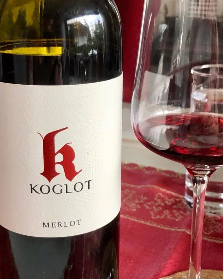Flasche Koglot Merlot mit einem Glas Rotwein